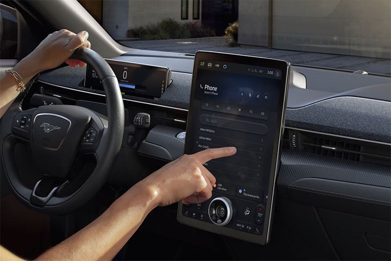 Driver using the touchscreen display inside a new Ford