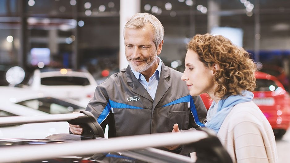 A Ford technician talking with a customer about their vehicle