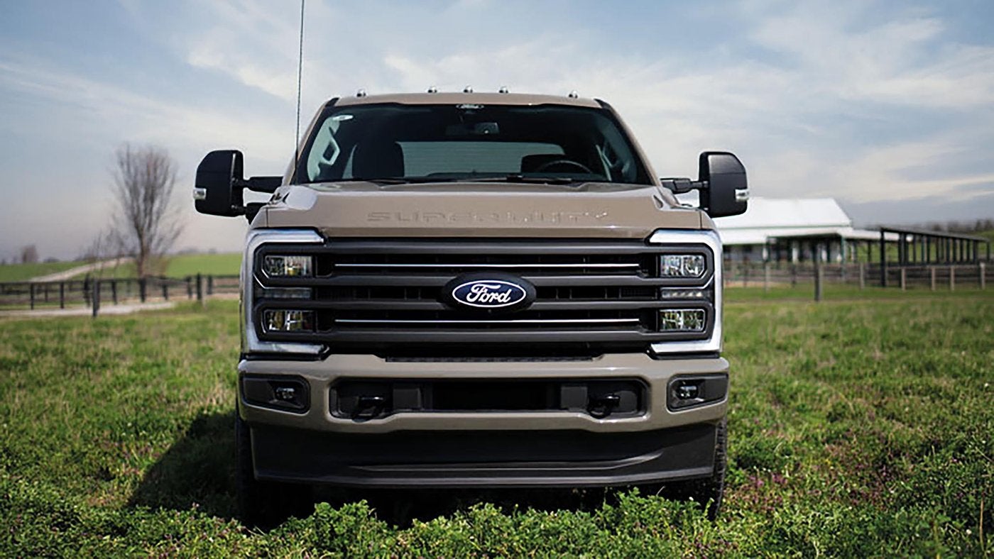 Tan 2027 Ford Super Duty F-250 XLT with the Carhartt package parked in a grassy farm field, Farmington MO