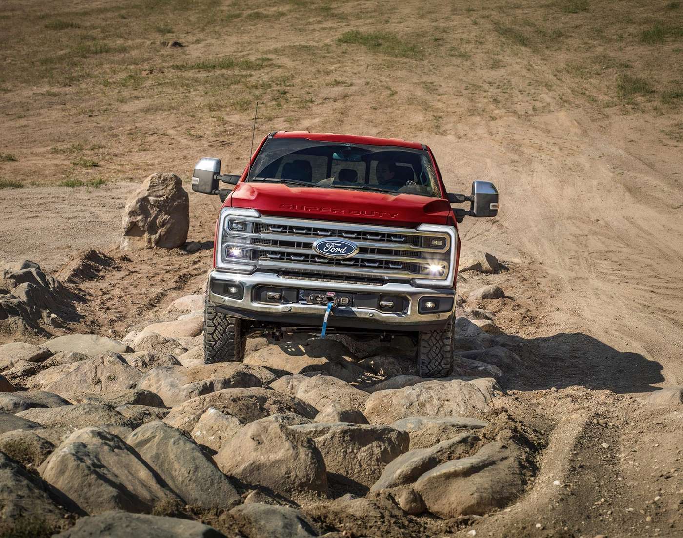 Red 2027 Ford Super Duty F-250 Tremor with a winch crawling over rocks, Farmington MO