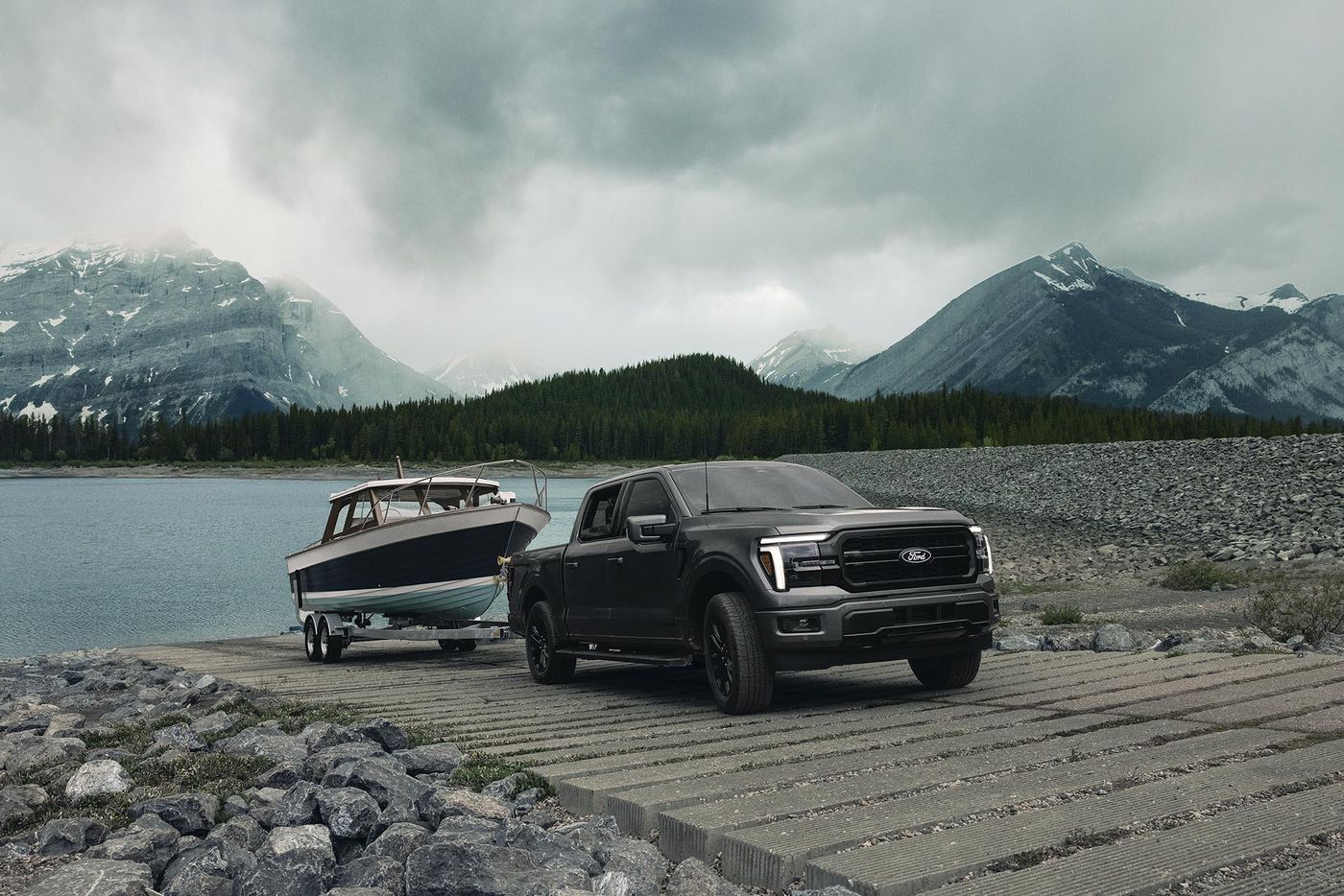 Black Ford F-150 Lariat pulling a boat out at a lake ramp, summer lake towing from Farmington MO