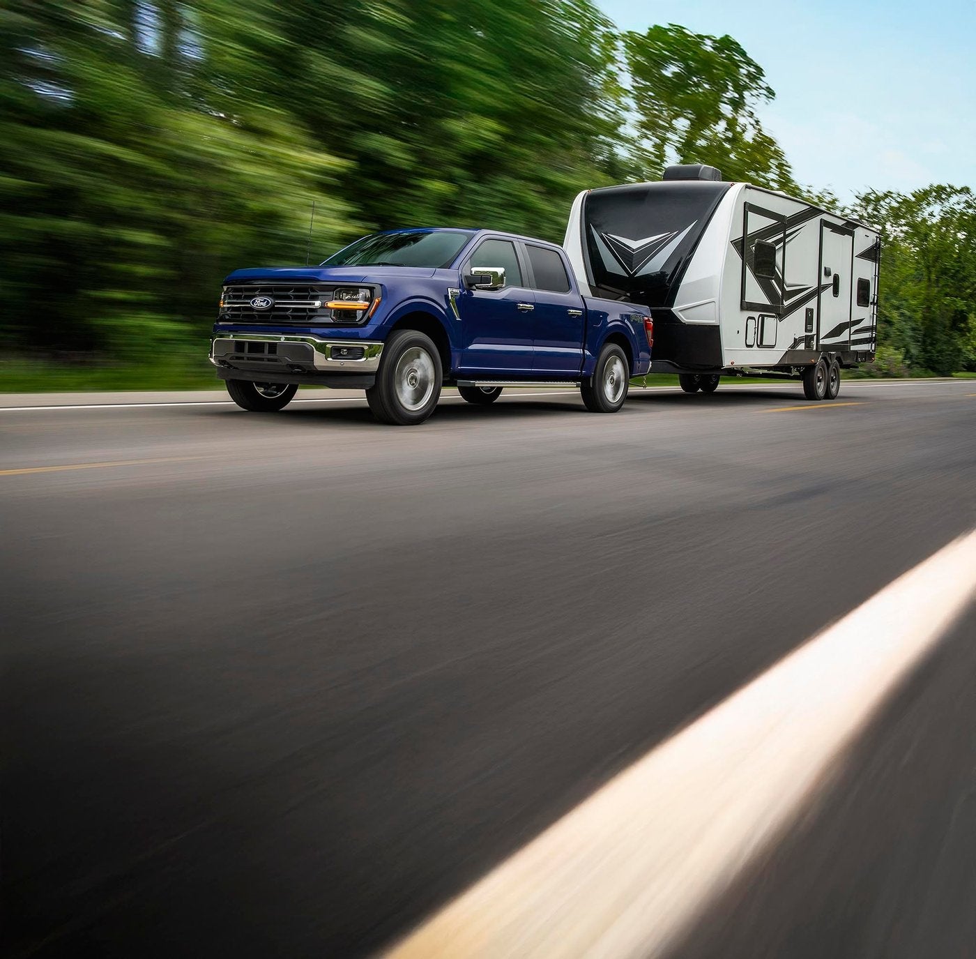 Blue Ford F-150 towing a travel trailer down a highway Blue Ford F-150 towing a travel trailer down a highway, the load a transmission feels, Farmington MO