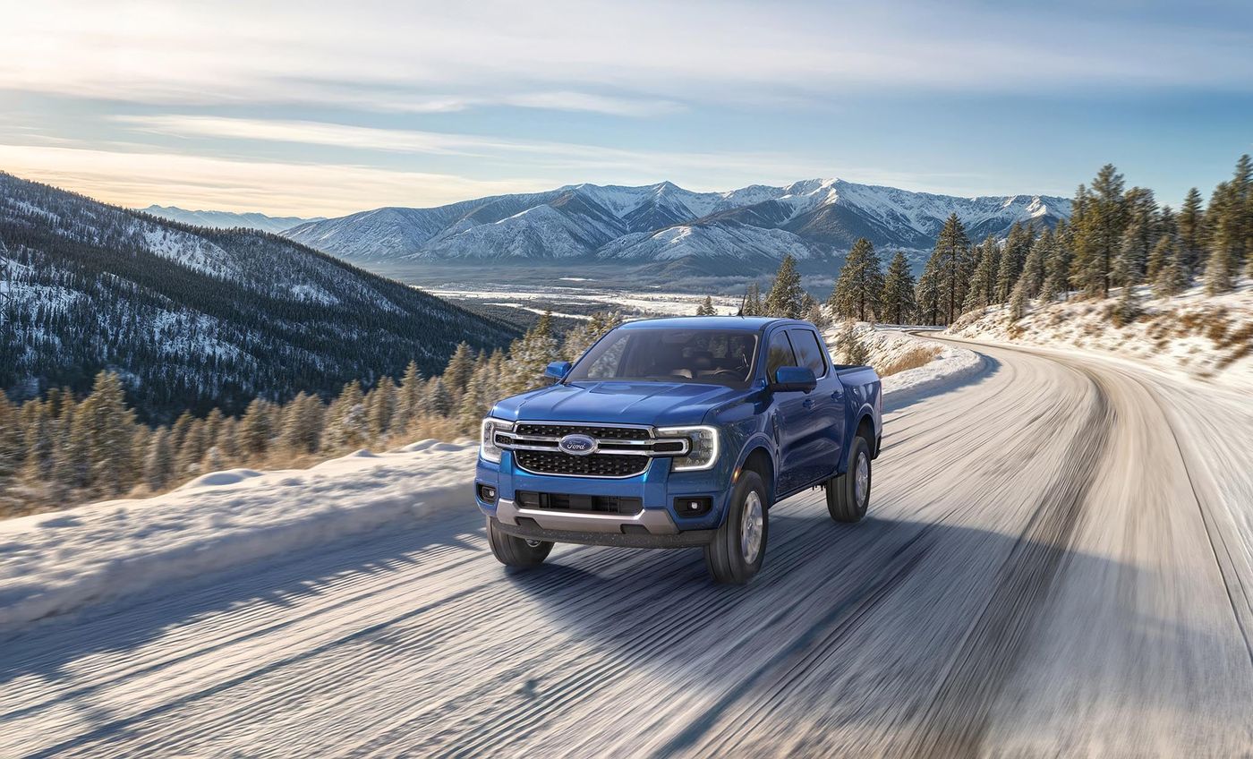 Blue Ford Ranger Lariat driving a snowy mountain road, winter prep for Farmington MO drivers