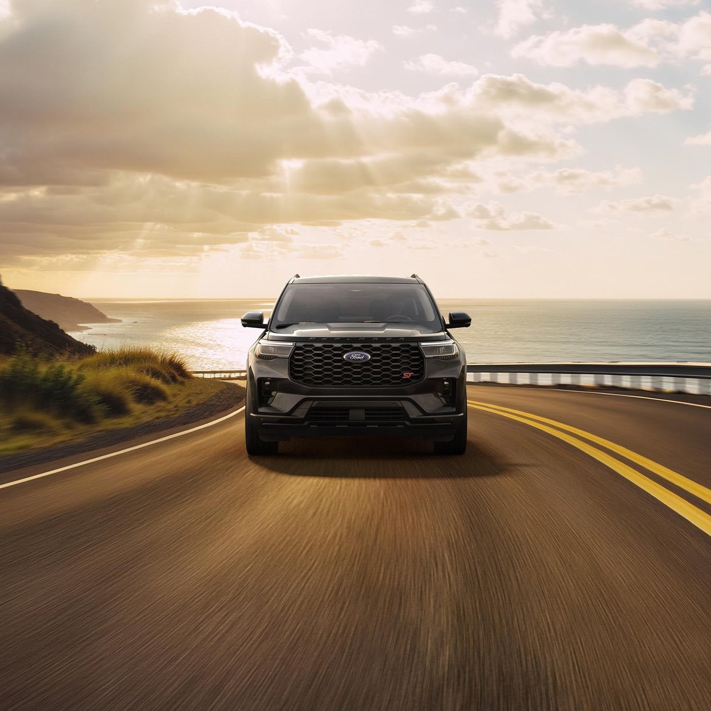 Dark Ford Explorer driving a coastal highway as the sun breaks through, summer driving before AC service, Farmington MO