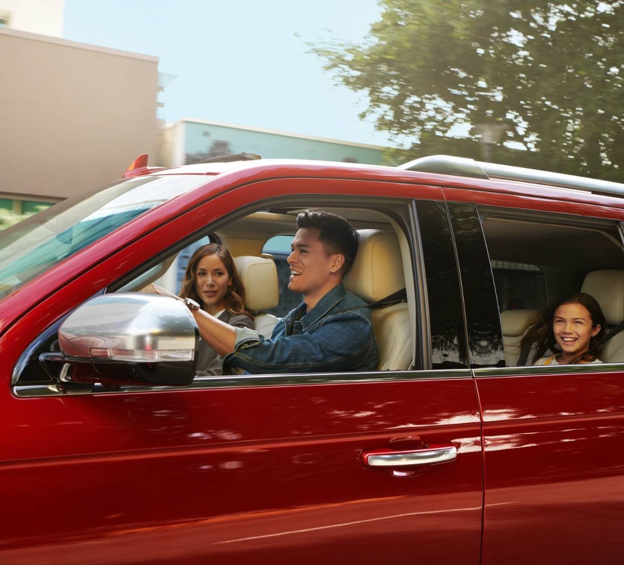 Smiling family riding in a red Ford SUV with dad at the wheel, ownership after the sale in Farmington MO