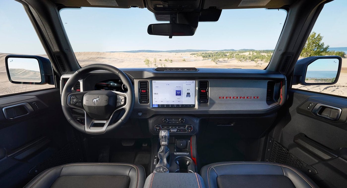 Ford Bronco dashboard and center touchscreen with sand dunes ahead through the windshield, Farmington MO