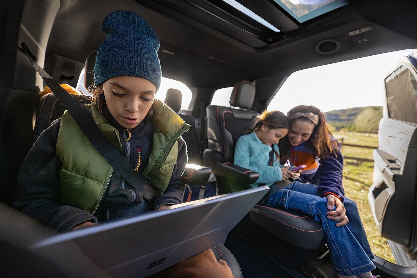 Kids using tablets in the second row of a Ford Explorer with the rear door open, family room for Farmington MO