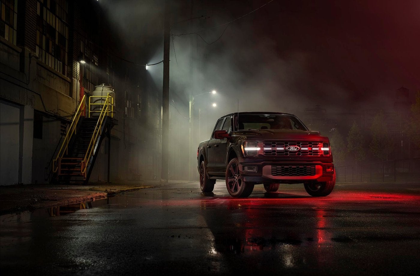Ford F-150 with its headlights and grille lights glowing on a dark wet street, night driving near Farmington MO