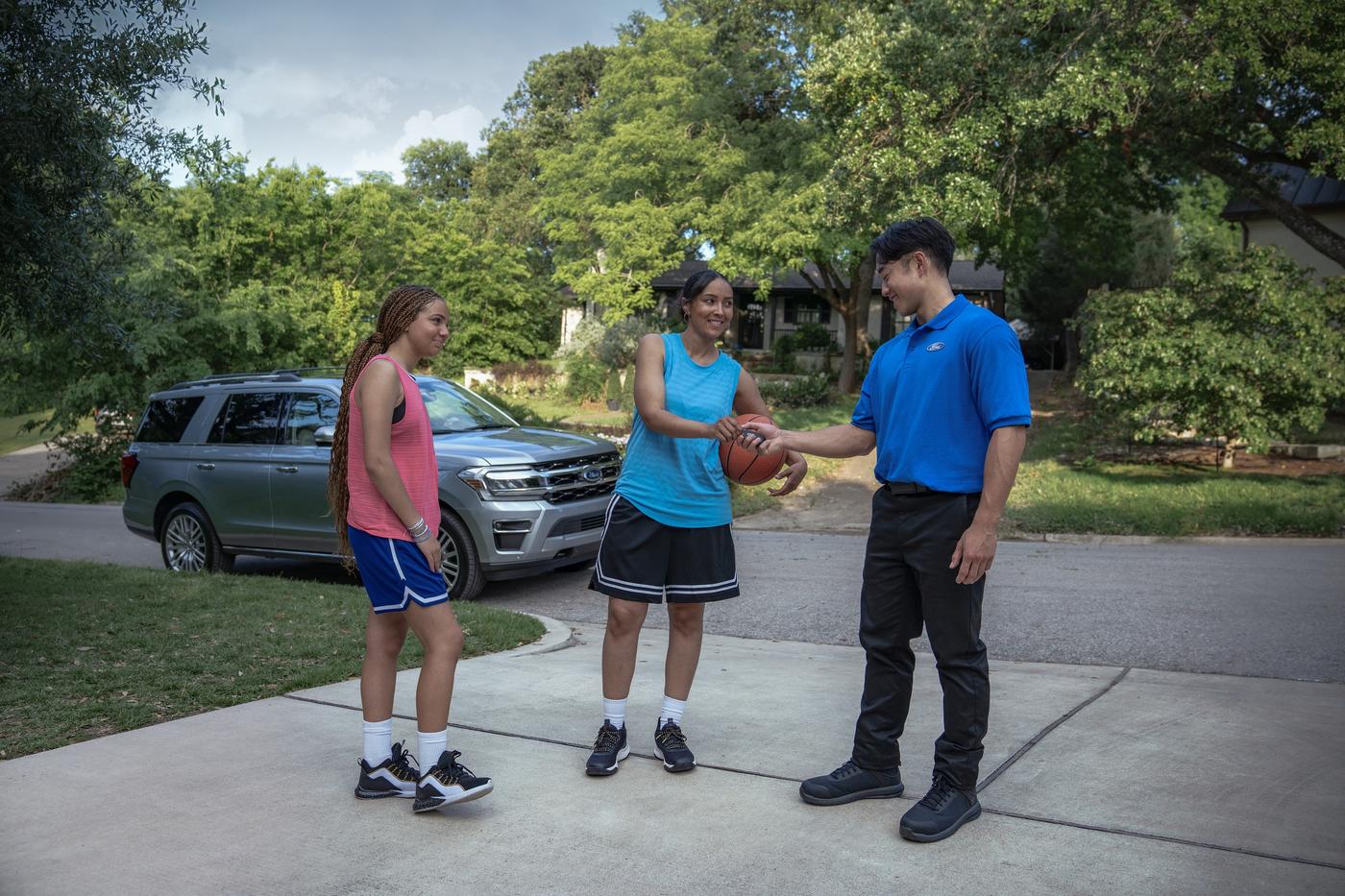 Ford Pickup and Delivery rep meeting two girls in a driveway with a gray Ford Expedition behind, Farmington MO