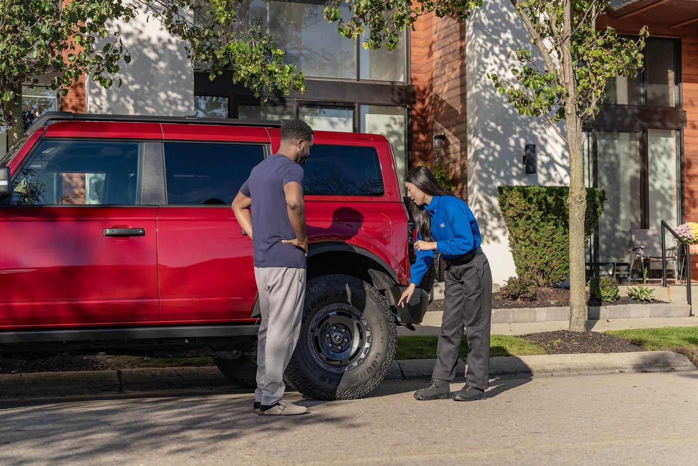Ford service rep going over the results with a Ford Bronco owner at the curb, check engine follow up in Farmington MO