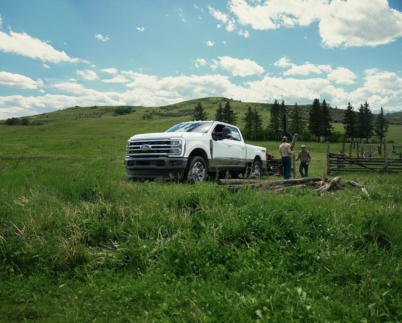 White Ford Super Duty parked in a pasture as a ranch crew unloads fence posts, Southeast Missouri work truck