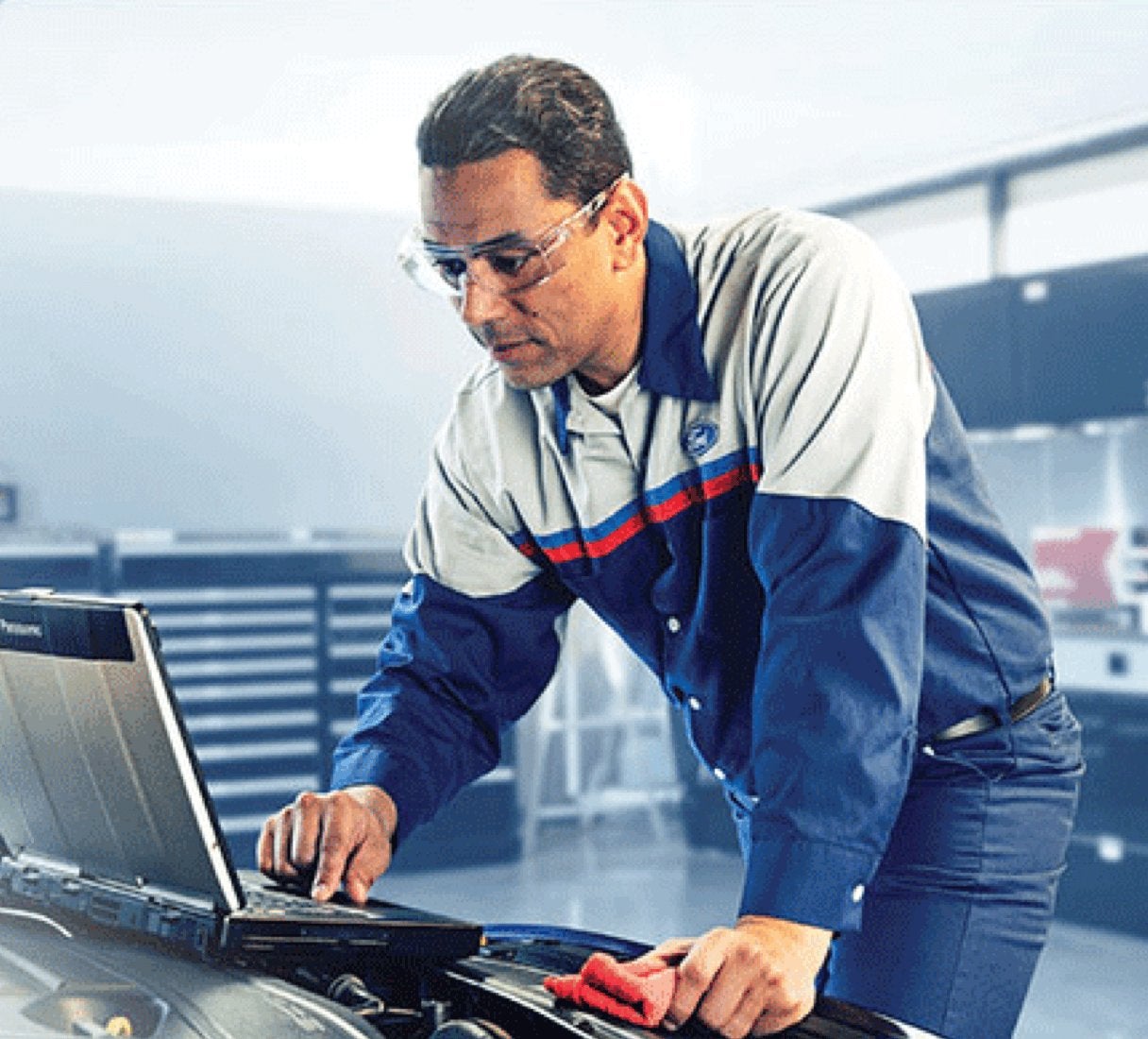 Ford technician running a computer diagnostic under an open hood, check engine light testing in Farmington MO