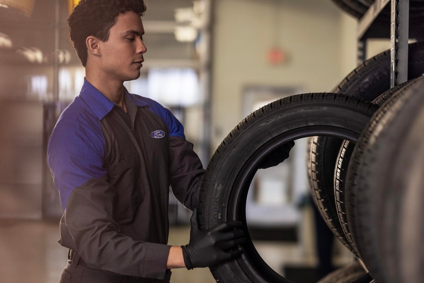 Ford technician pulling a new tire from the tire rack in the service department Ford technician pulling a new tire from the tire rack in the service department, tire service in Farmington MO