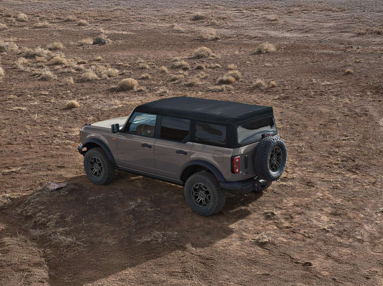 Gray four door Ford Bronco with its cloth roof on, parked on a dirt hill, weekend trips from Farmington MO