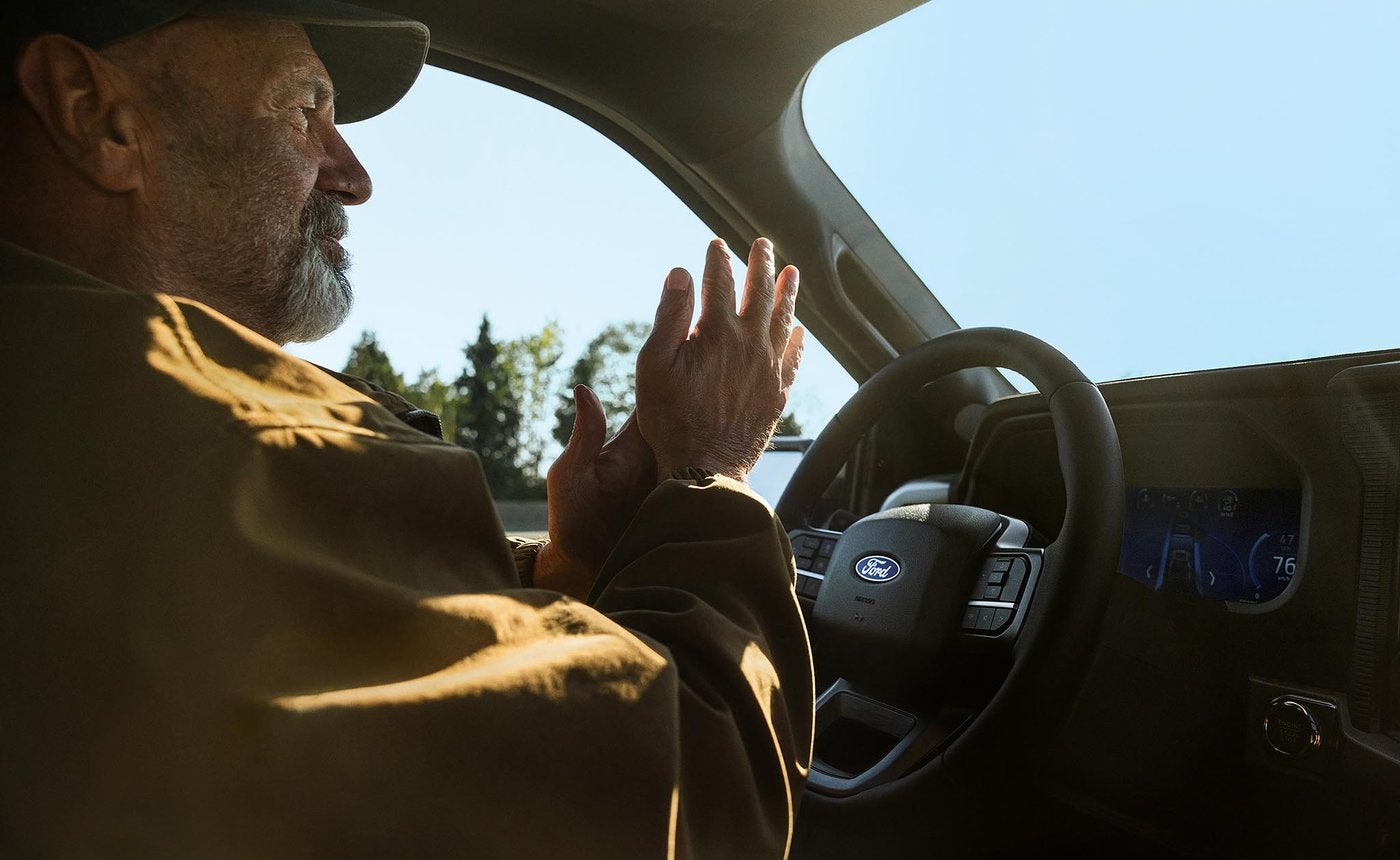 Man driving a Ford F-150 with BlueCruise hands free on the highway, commuting miles from Farmington MO