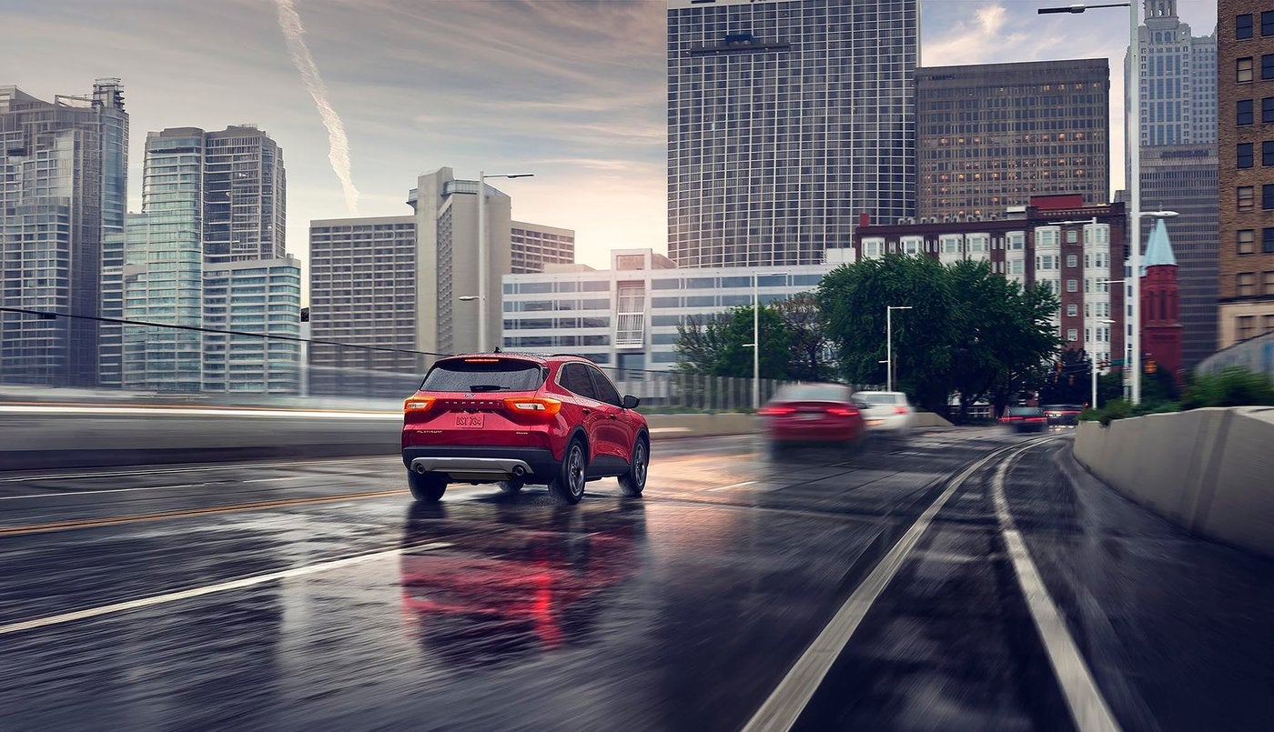 Red Ford Escape driving a wet highway toward the city, the daily commute for Farmington MO drivers