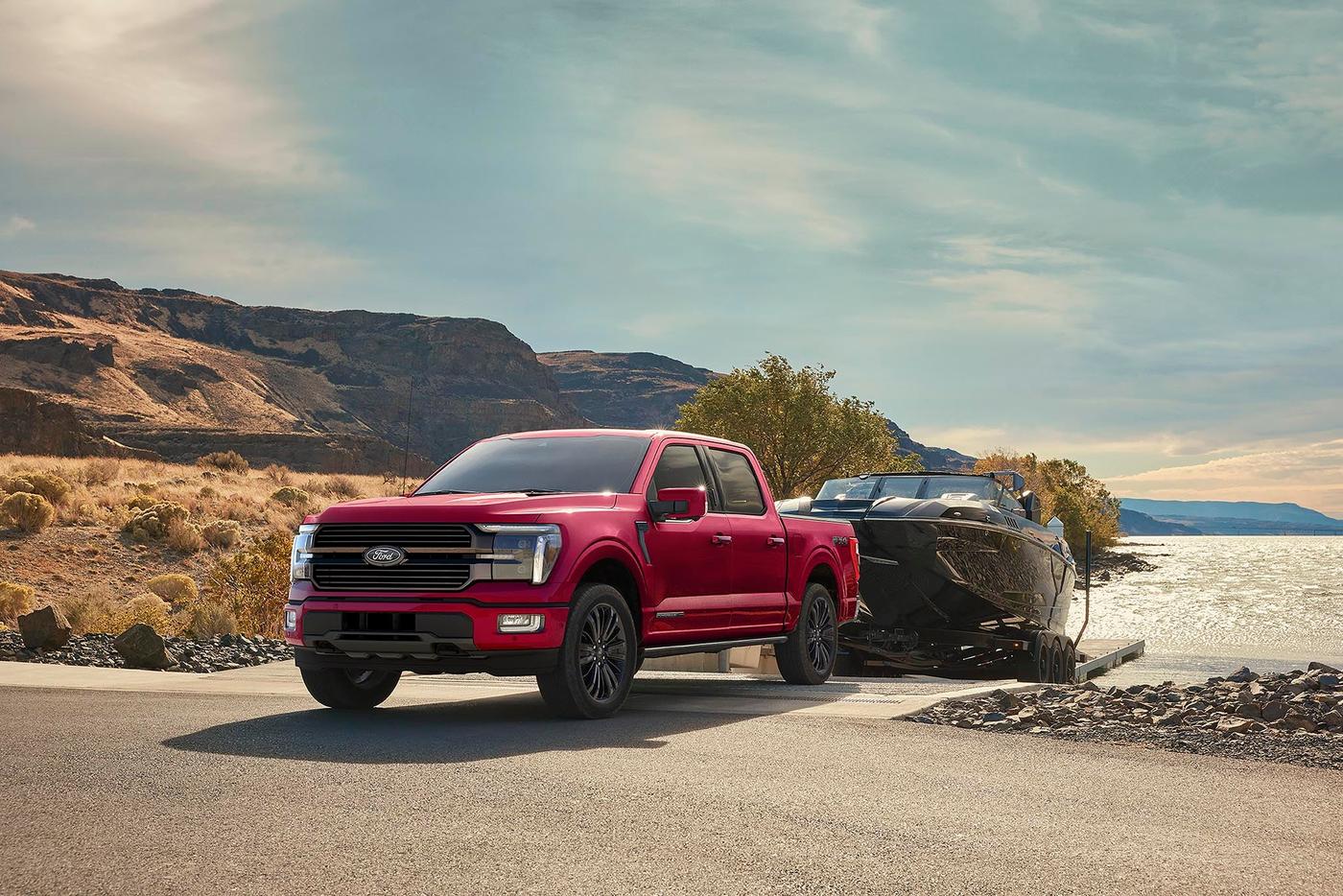 Red Ford F-150 Platinum hitched to a boat at a lakeside ramp, Warranty Forever at Sam Scism Ford in Farmington MO