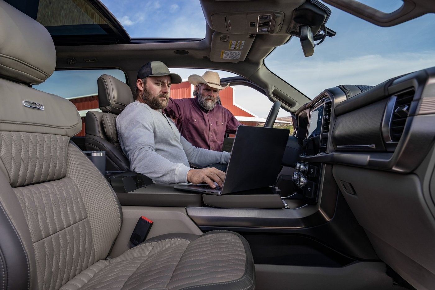 Two men working on a computer at the fold out work surface inside a Ford F-150 Platinum Two men working on a computer at the fold out work surface inside a Ford F-150 Platinum, Farmington MO