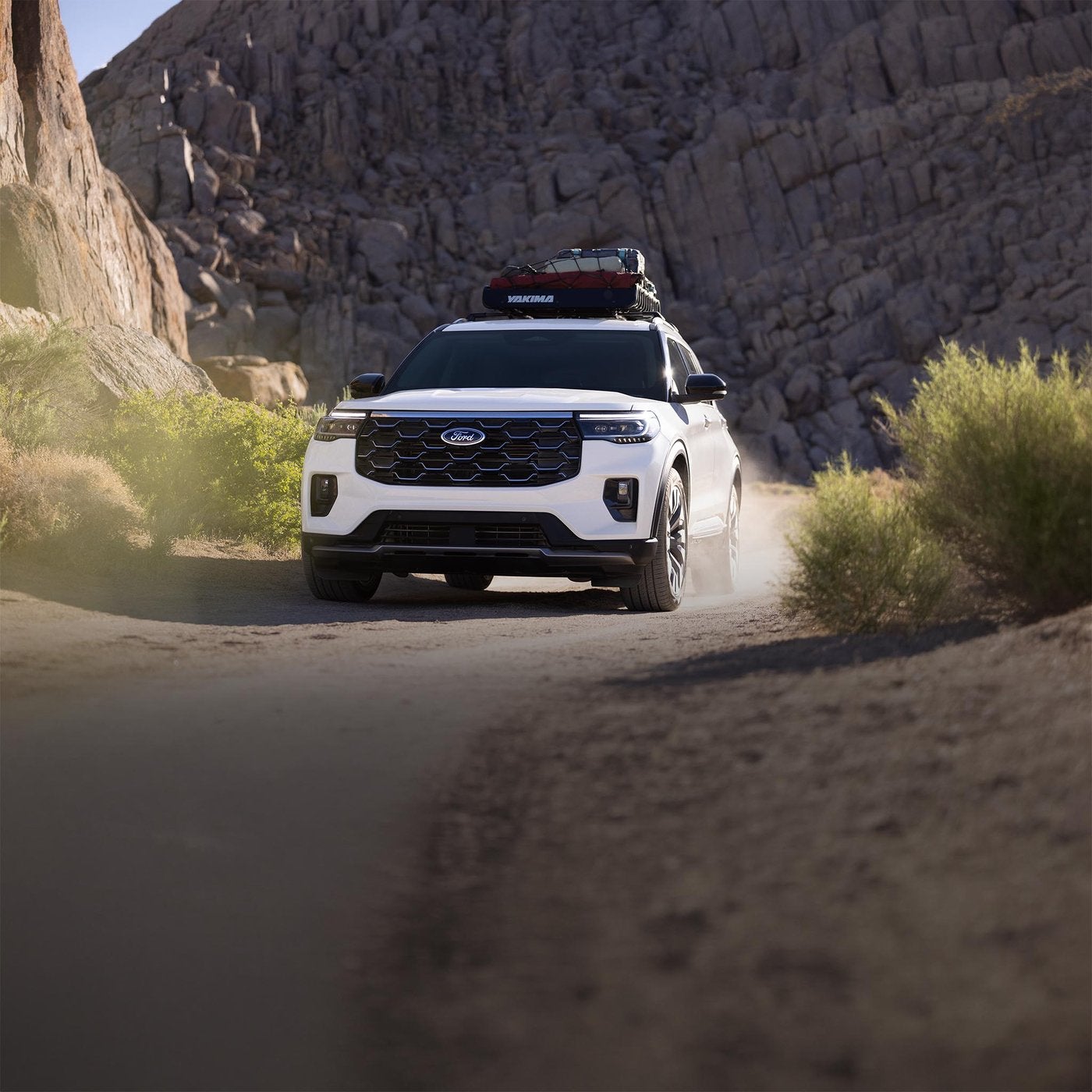 White Ford Explorer Platinum with a roof box driving a canyon trail, a family SUV for Farmington MO